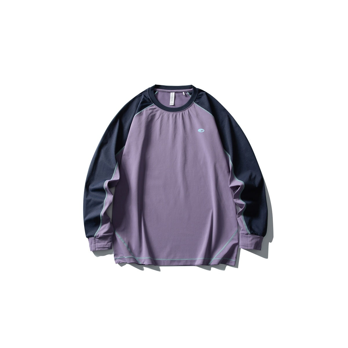 Front of a purple long-sleeve raglan tee with navy sleeves, light teal contrast stitching and a small chest logo