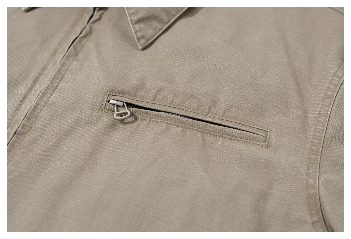 Close-up of a horizontal zippered chest pocket on the taupe jacket.