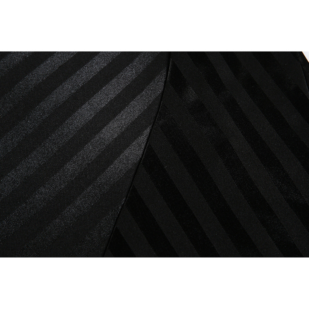 Close-up of black fabric with alternating subtle stripes and a curved garment seam.