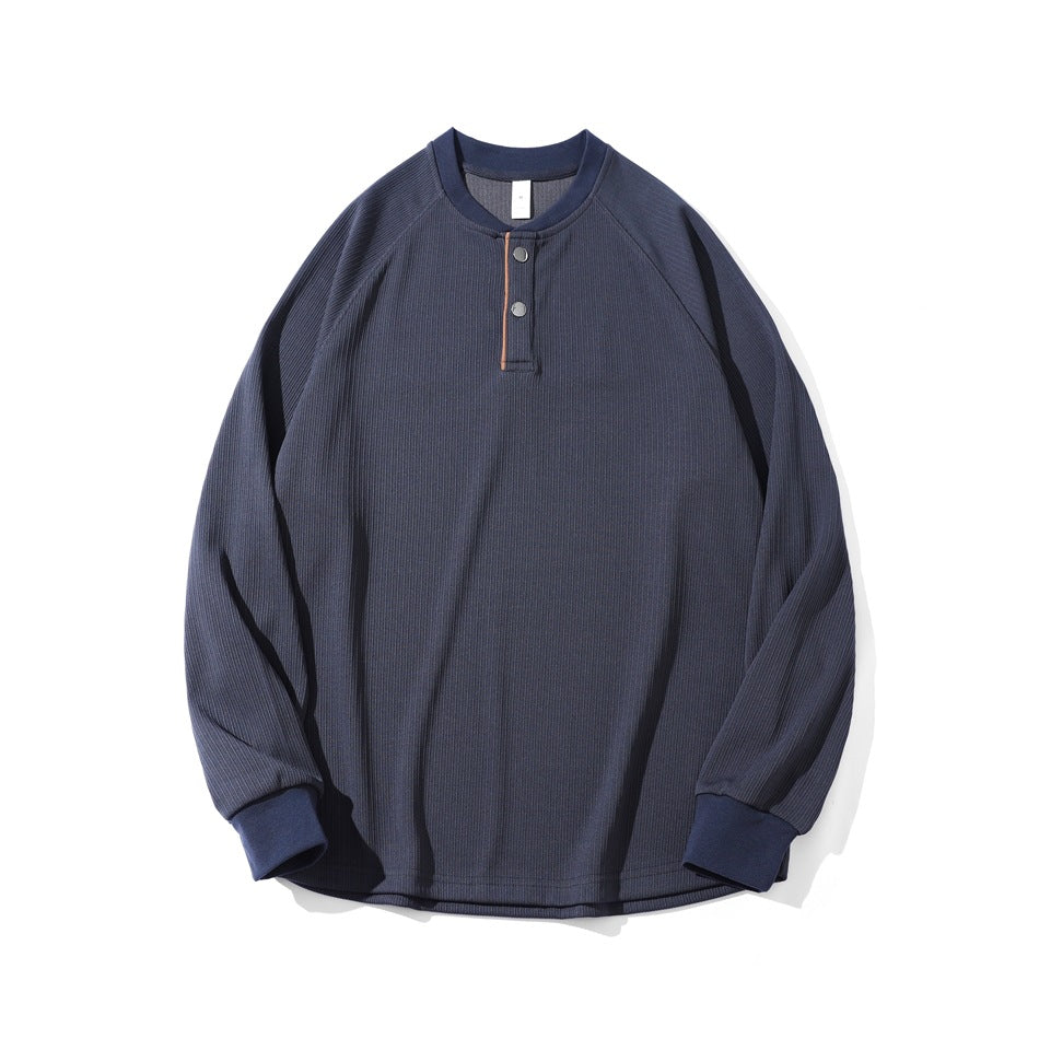 Blue ribbed long-sleeve henley top with two snaps, raglan sleeves and ribbed cuffs, flat lay