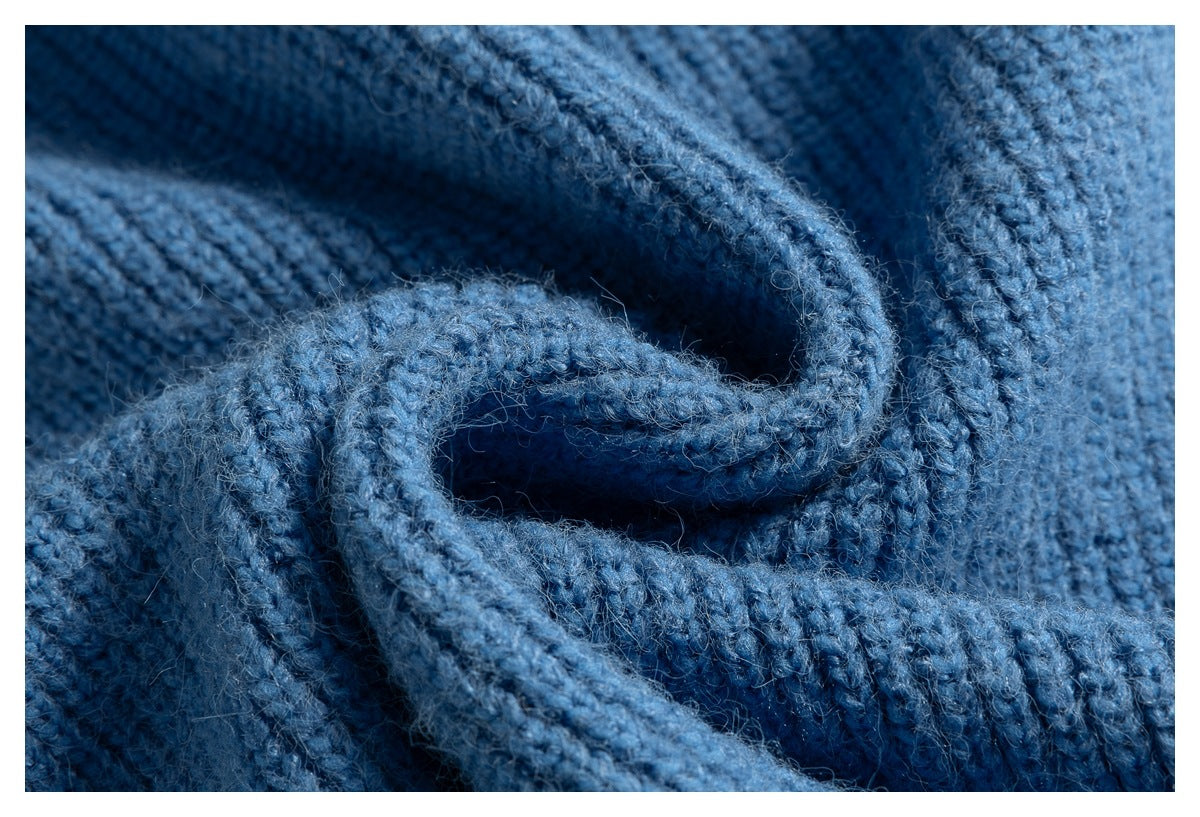 Close-up of the blue sweater’s ribbed knit fabric and folded edge.