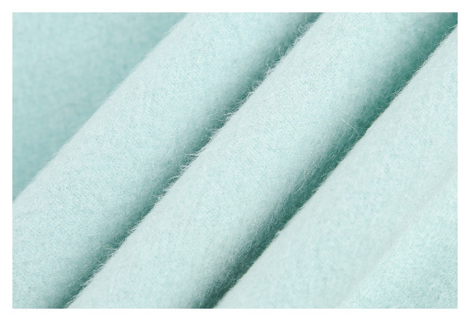 Extreme close-up of soft-looking mint garment fabric in overlapping folds.