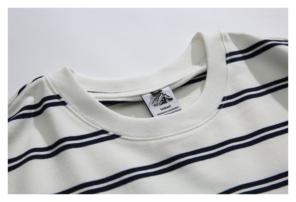 Close-up of the ivory shirt’s ribbed crew neckline, navy stripes, and sewn-in neck label.