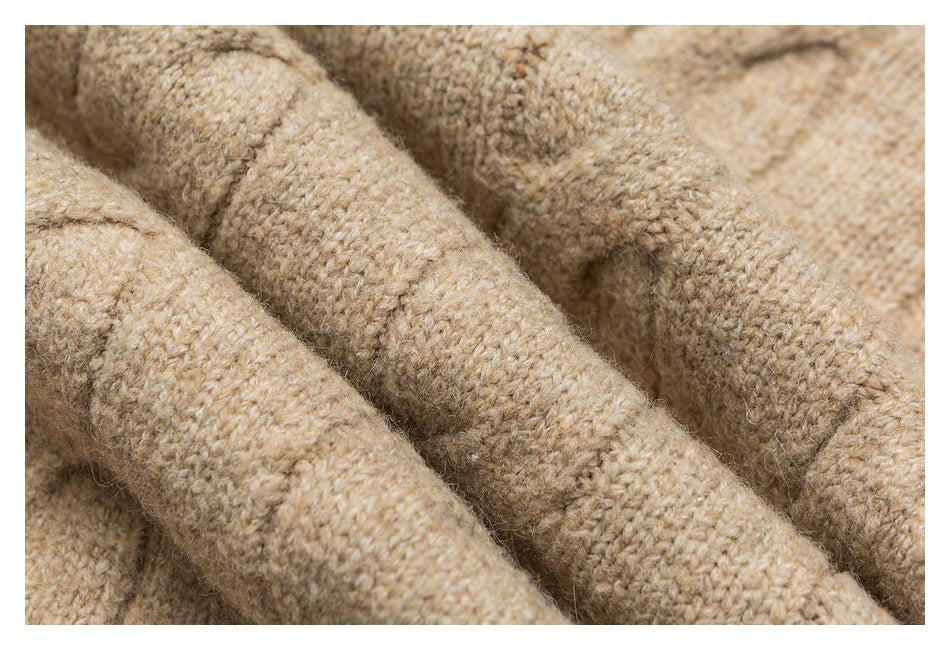 Macro view of the beige sweater's textured knit stitches.