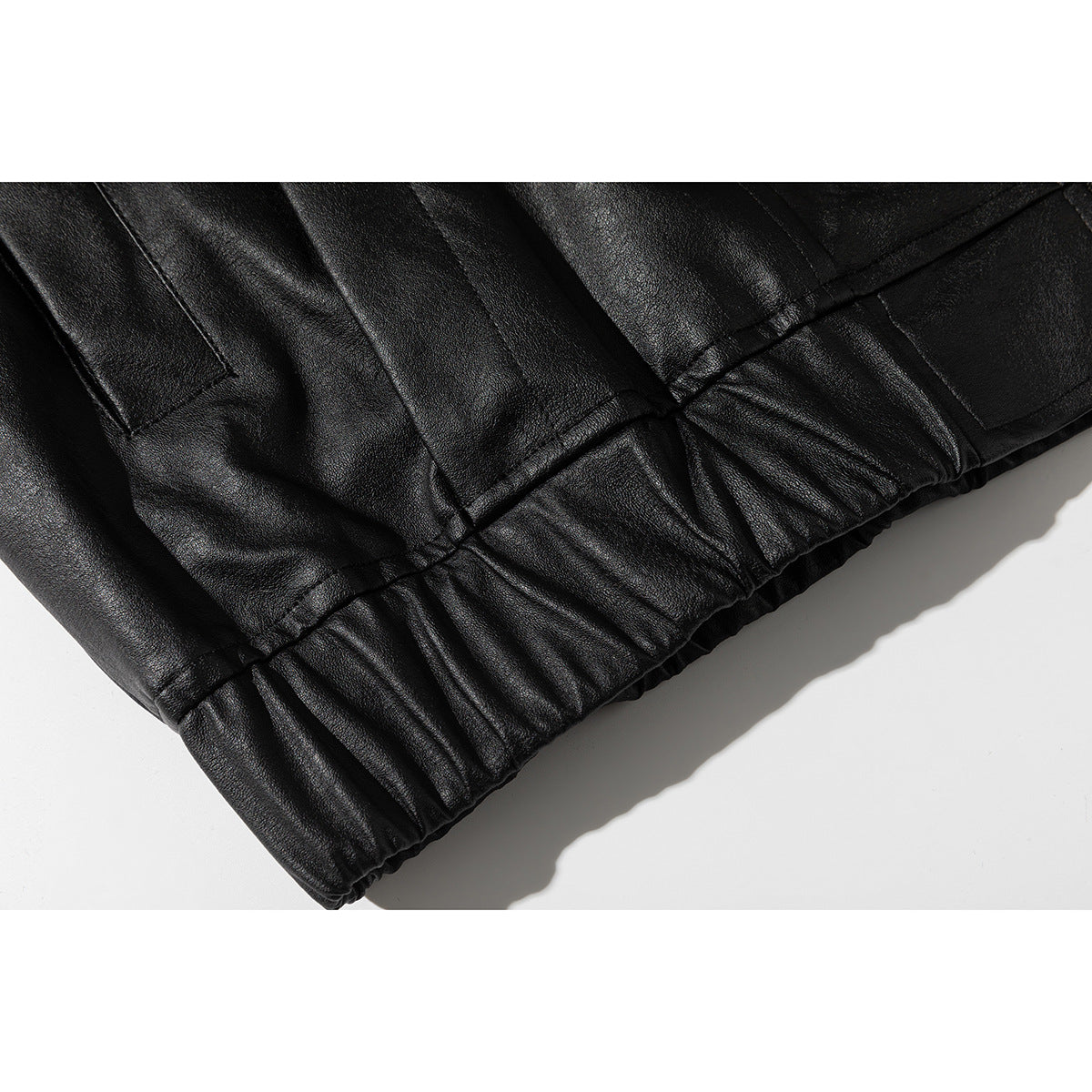 Close-up of the black jacket's gathered elastic hem and seam details.