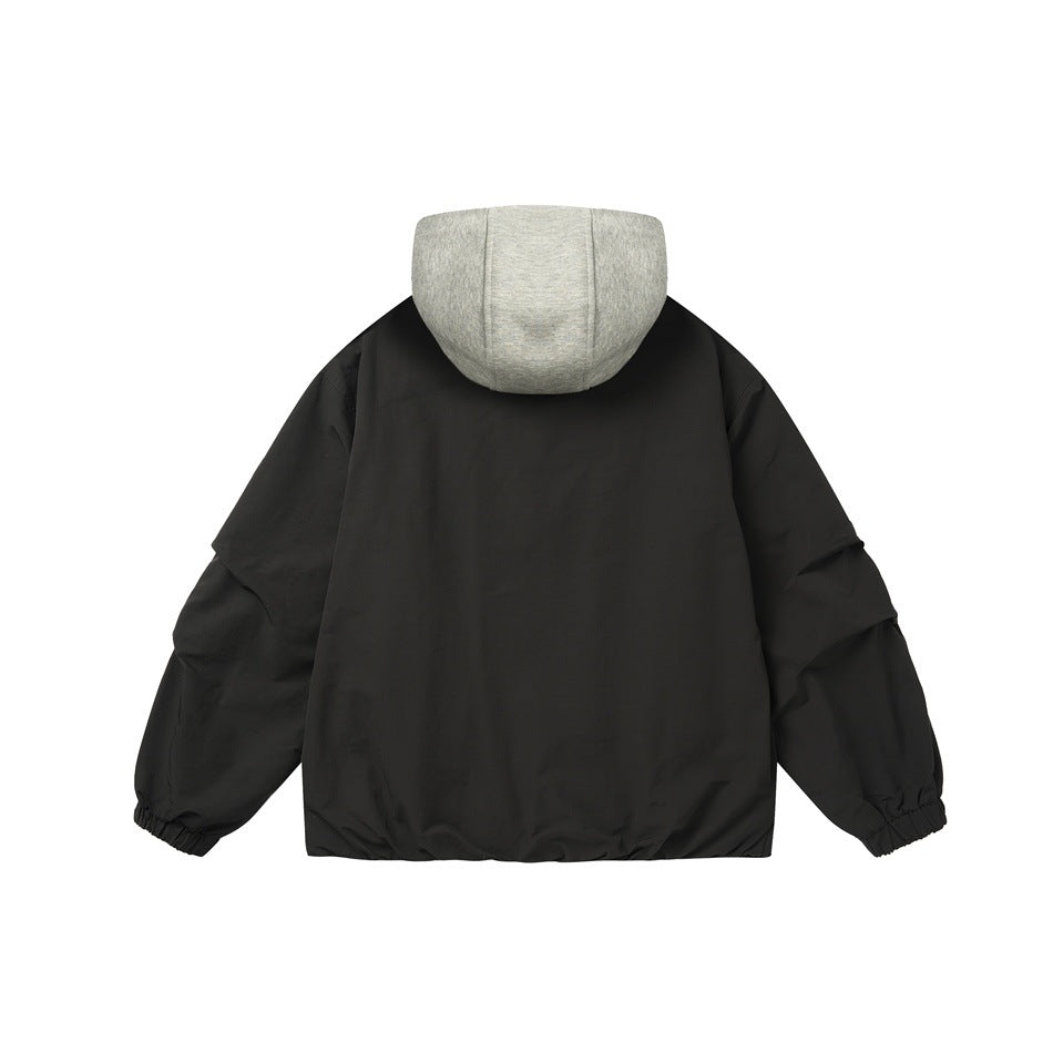 Back view of a black jacket with a light gray hood and gathered elastic cuffs.