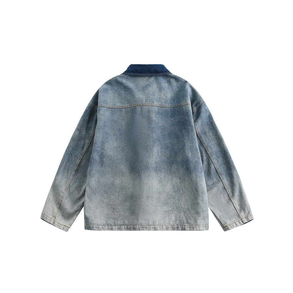 Back view of a faded blue denim jacket with long sleeves and a dark indigo collar.