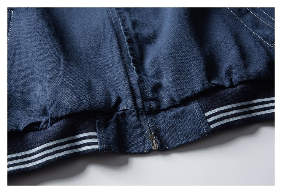Close-up of a dark navy garment hem with a short zipper and striped ribbed trim.