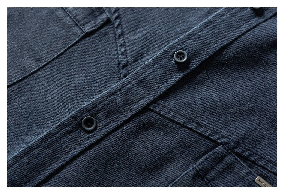Close-up of dark indigo denim with two black buttons, a stitched placket, and part of a sewn label.