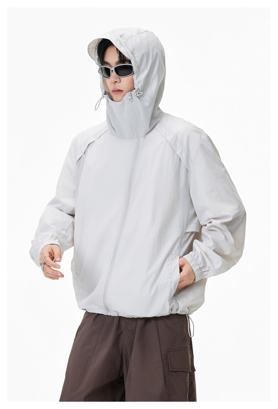 Model wearing a white hooded windbreaker with the hood raised, high collar, and front zipper.