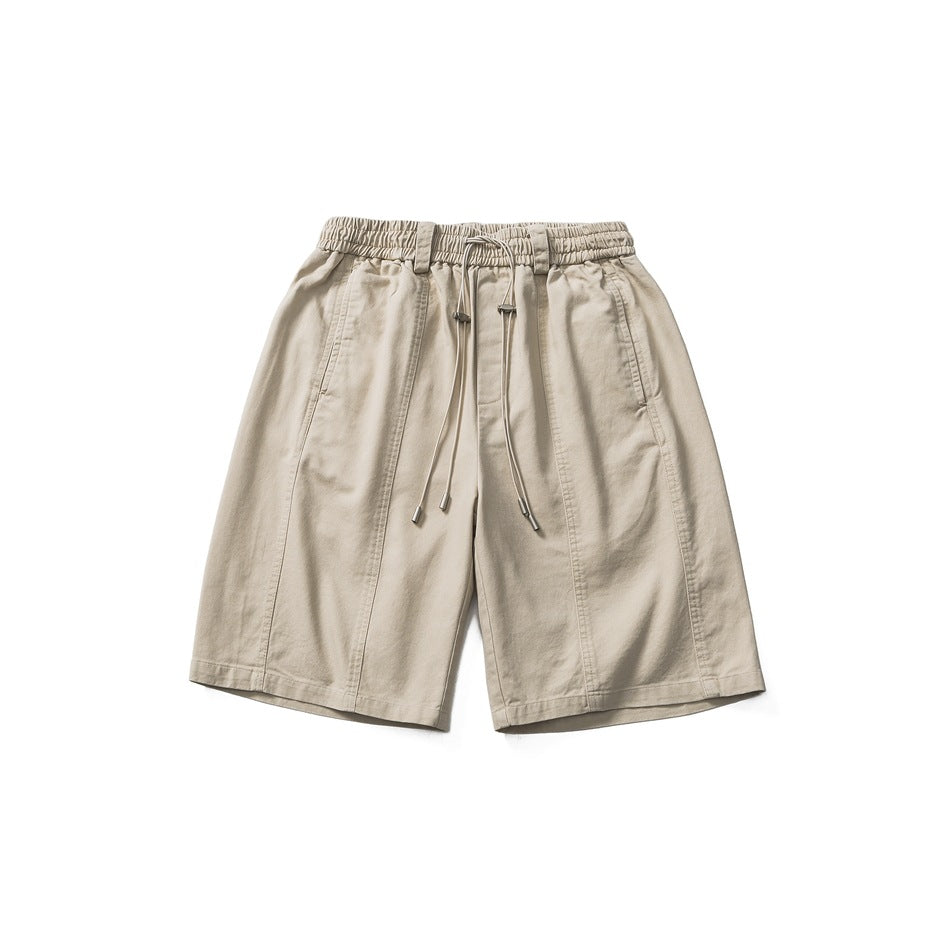 Light khaki drawstring shorts with elastic waist and side pockets, flat lay front view