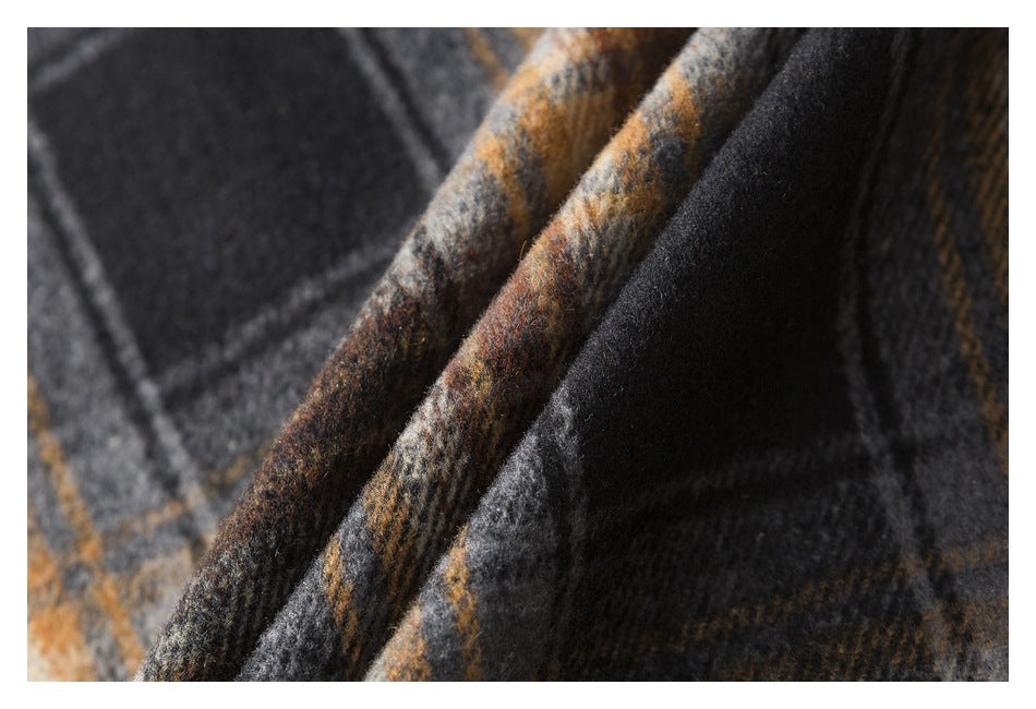 Macro view of folded brown, gray, and black plaid fabric showing its woven texture.
