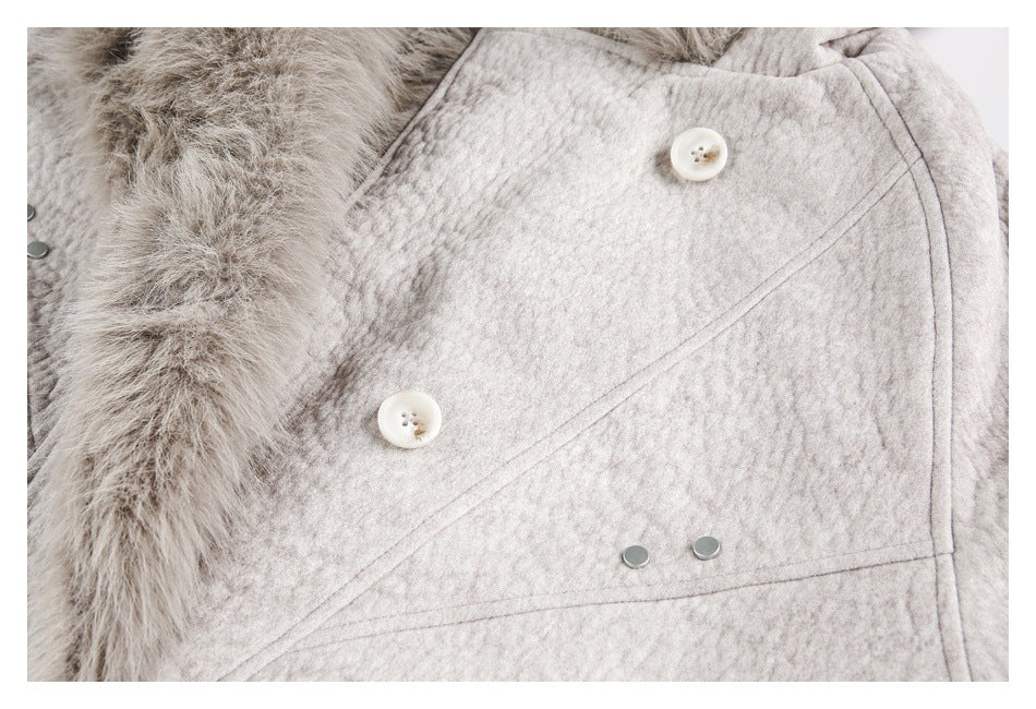 Close-up of the jacket front showing pale buttons, metal snaps, fur trim, and textured light gray fabric.