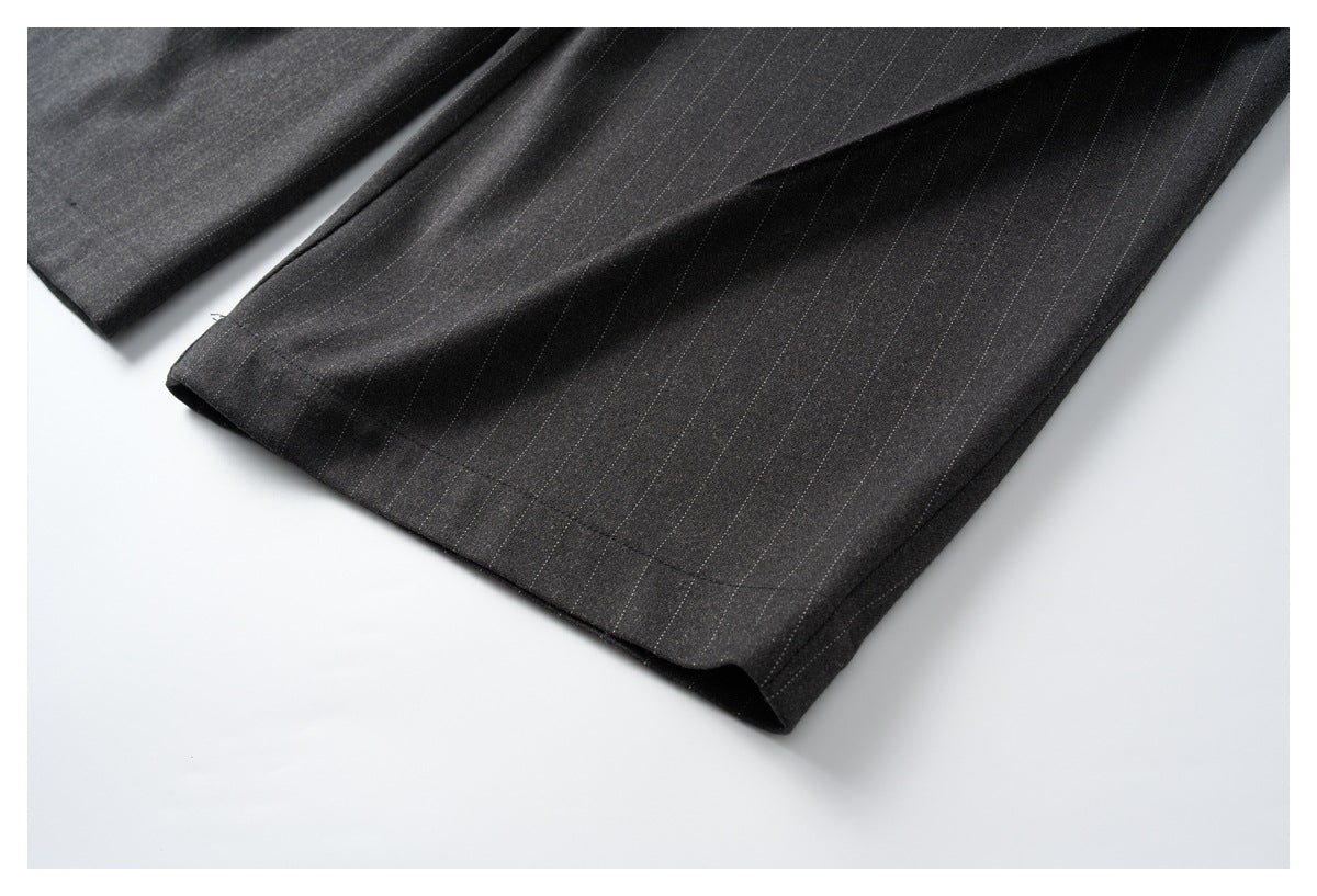 Close-up of the charcoal pinstripe trouser leg and stitched hem.