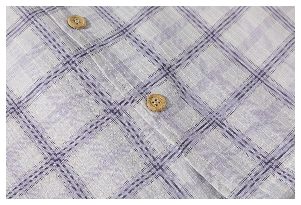 Close-up of the light gray-lavender plaid shirt's front placket with two tan buttons.