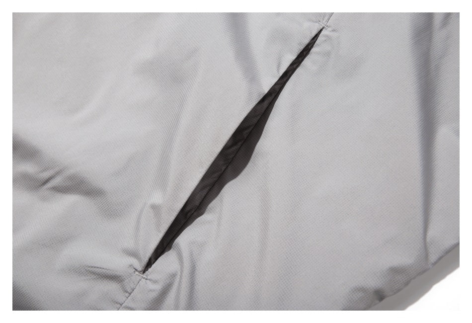Close-up of a narrow slit opening in the light gray jacket fabric.
