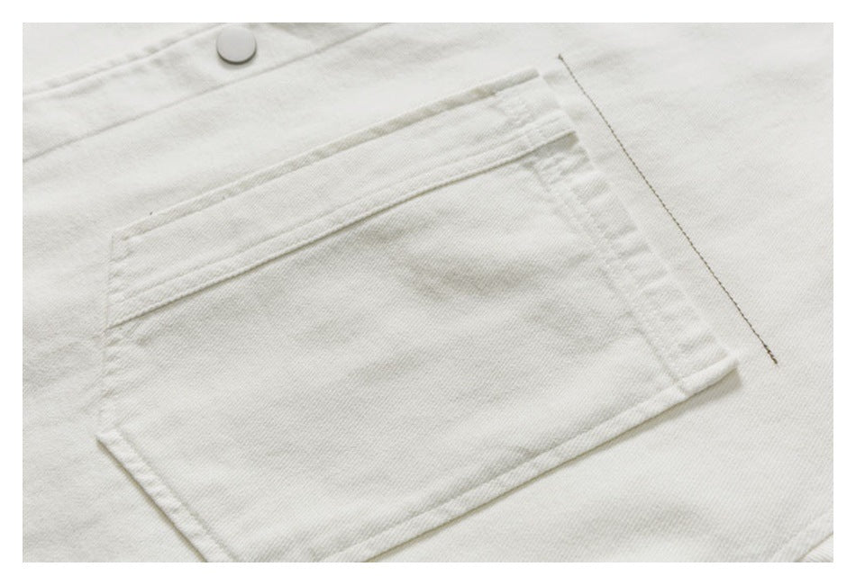 Close-up of a large stitched rectangular pocket on off-white fabric, with a snap button above it.