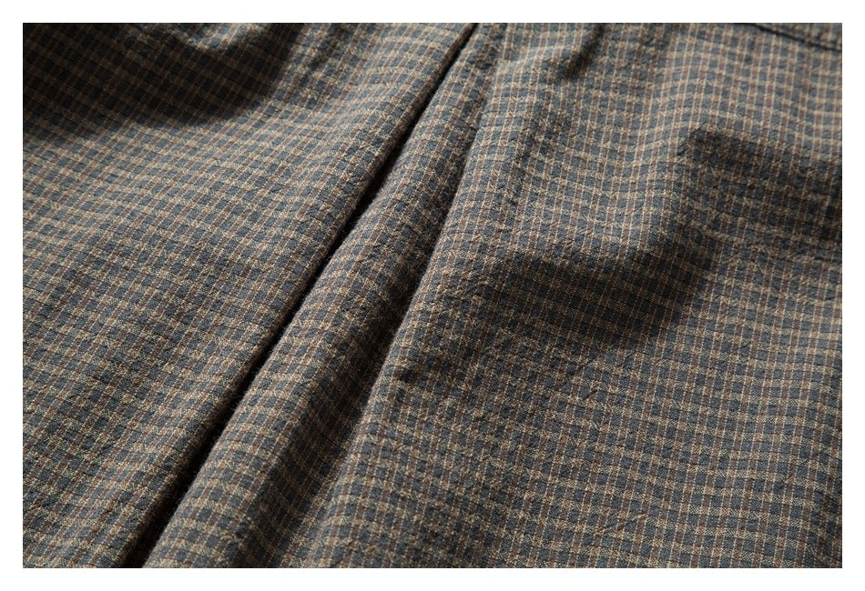 Close-up of a folded placket and checked fabric on the garment.