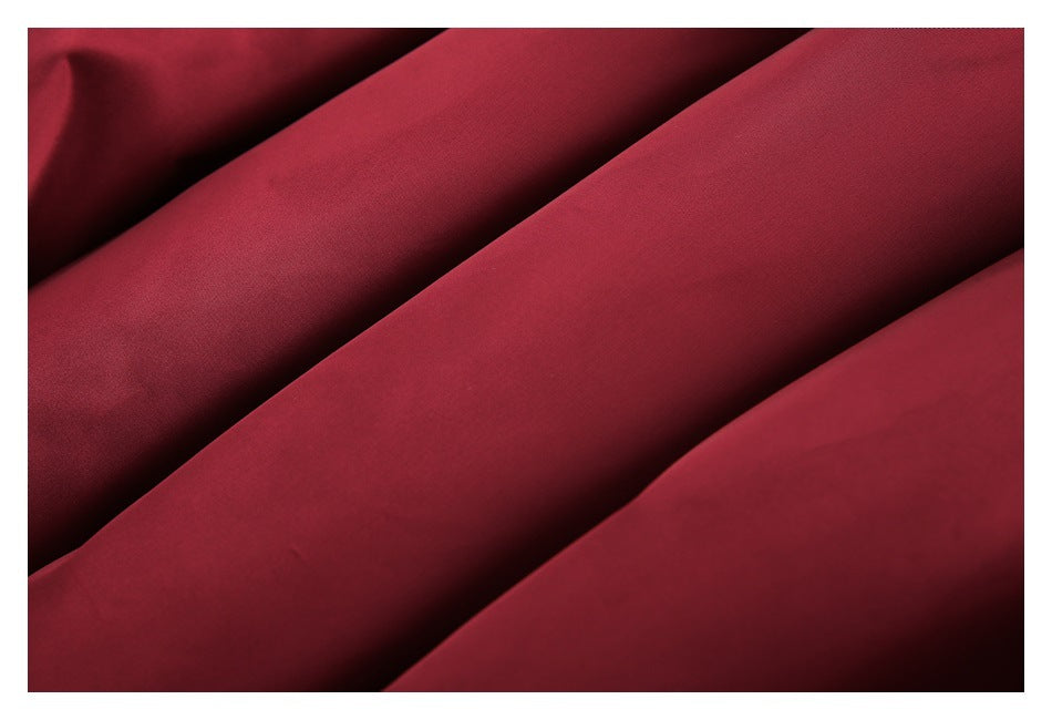 Close-up of smooth burgundy jacket fabric arranged in folds.