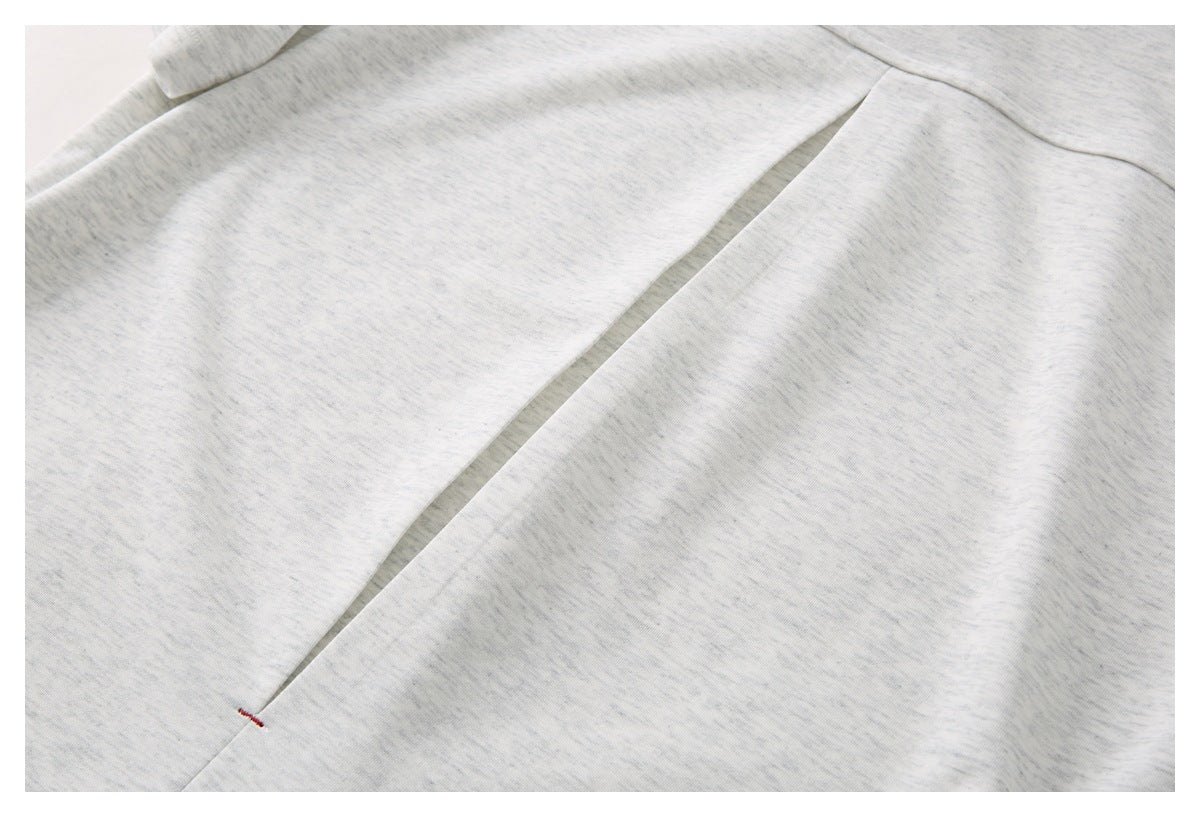 Close-up of a long stitched opening or seam on the light gray heather polo shirt.