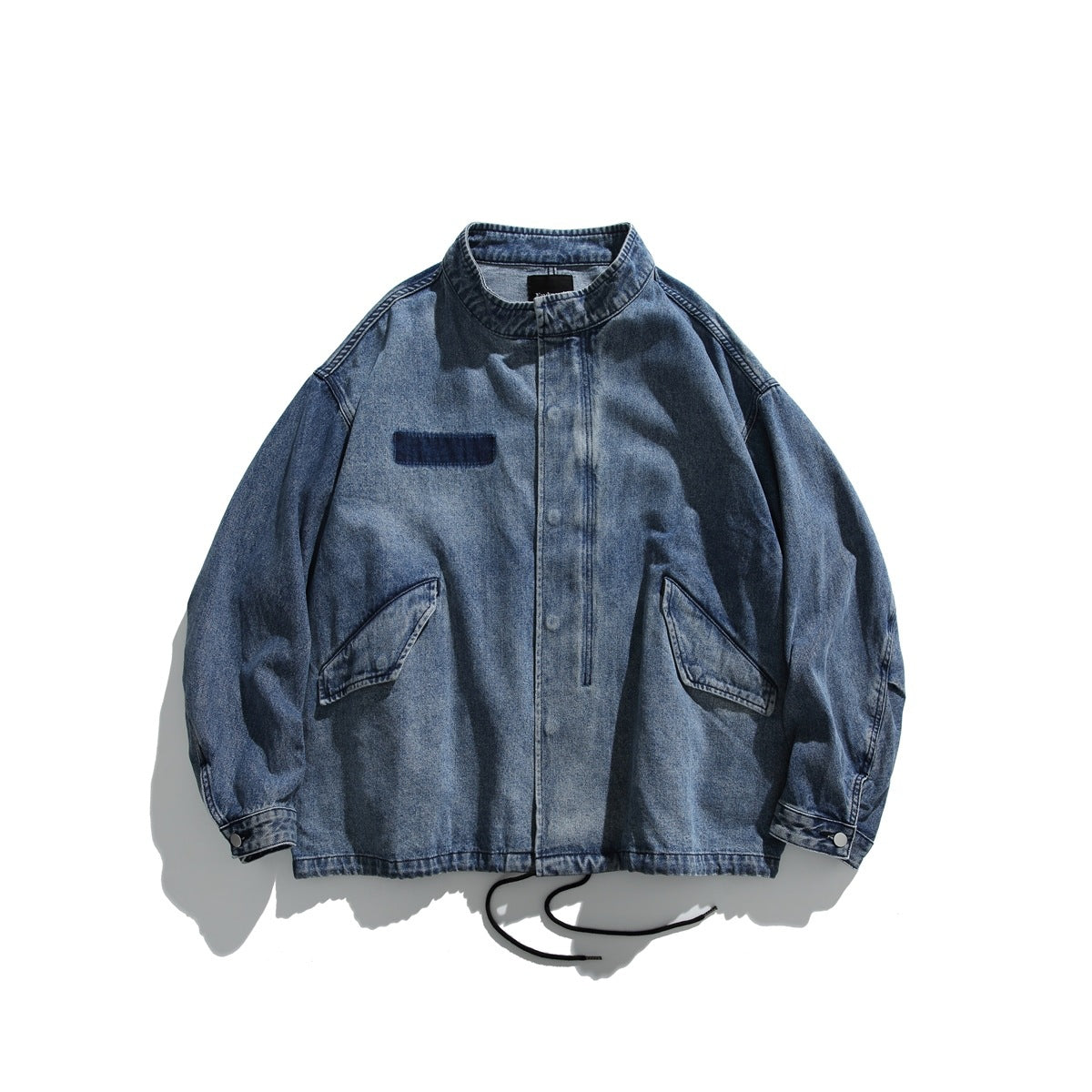 Blue washed denim stand-collar jacket flat lay with snap front, flap pockets and drawstring hem
