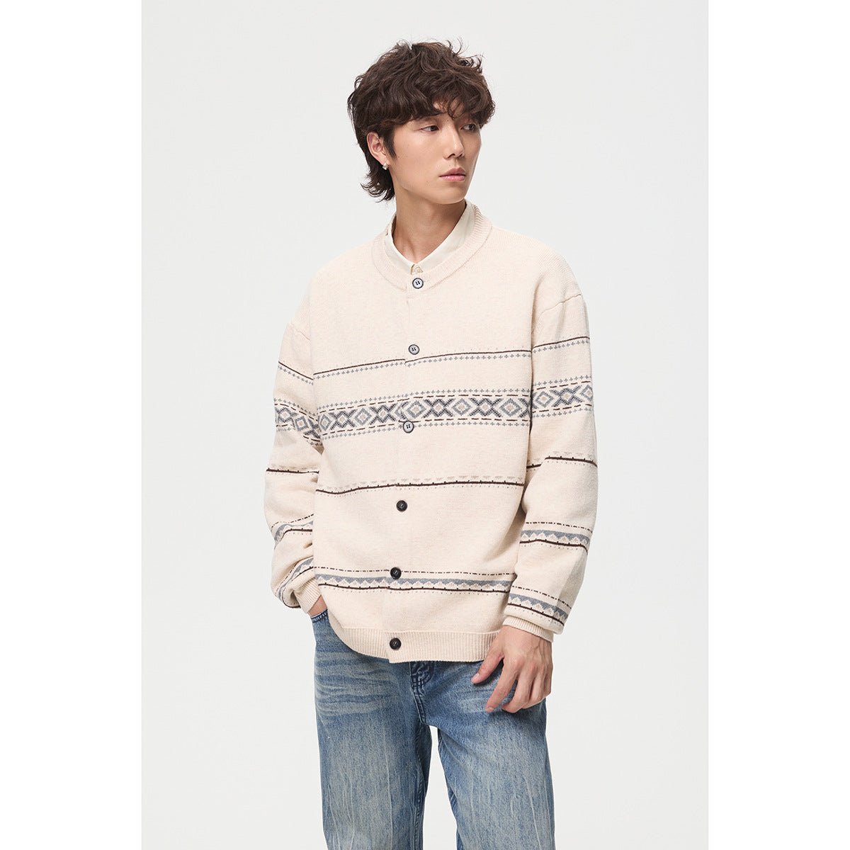 Man wearing a cream button-front cardigan with gray geometric stripe patterns, shown from the front.