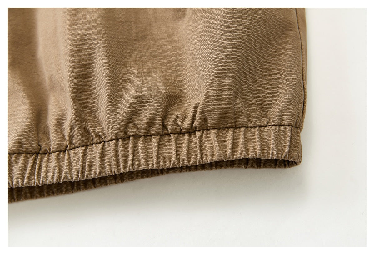Close-up of the gathered elastic hem on a tan garment.