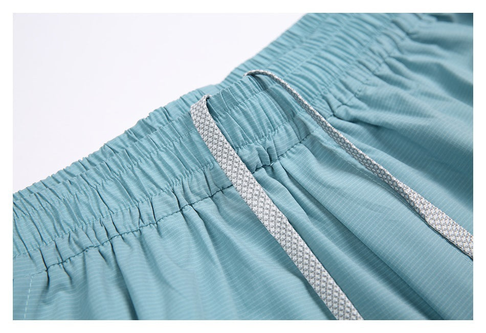 Close-up of the gathered waistband and textured white drawstrings on the shorts.