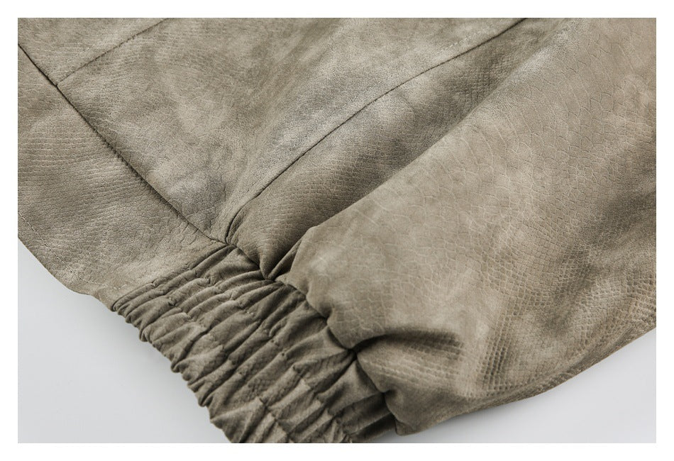 Close-up of a taupe jacket with a gathered elastic edge and textured panels.