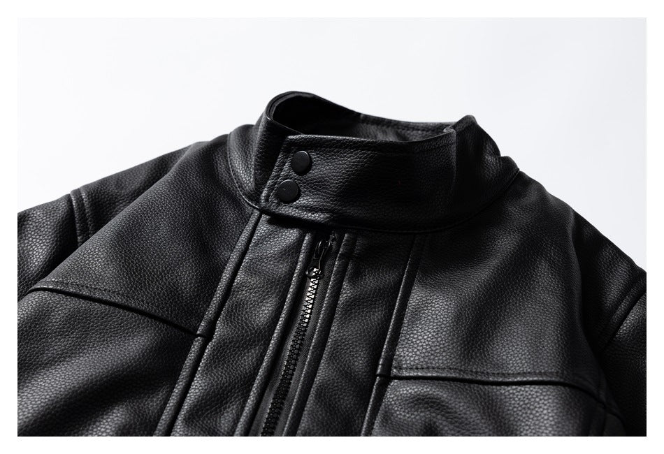 Close-up of a black jacket's snap collar, front zipper, and stitched chest panels.