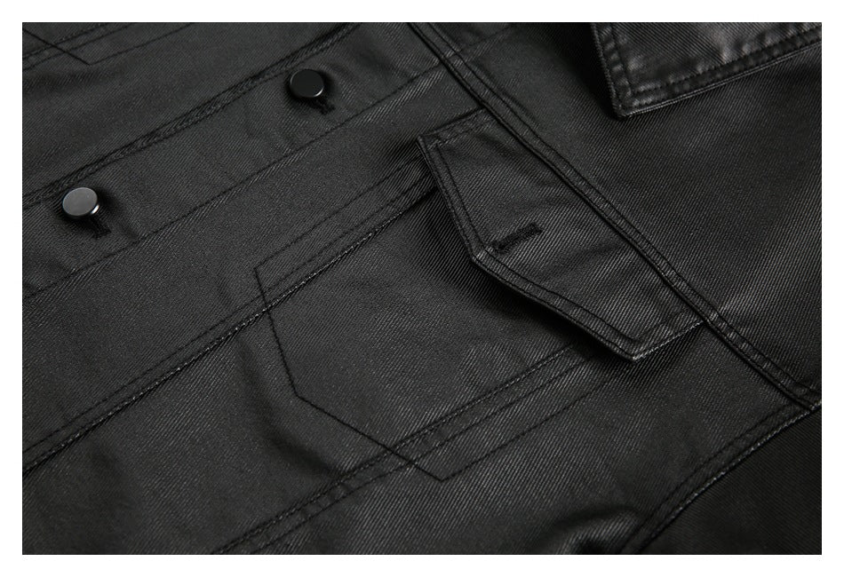 Close-up of a black jacket front pocket flap, stitching, and two black snaps.