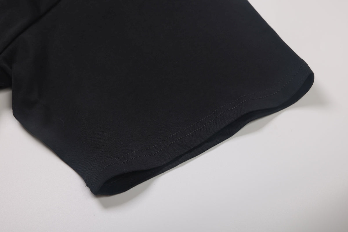 Close-up of the black T-shirt's stitched sleeve or hem edge.