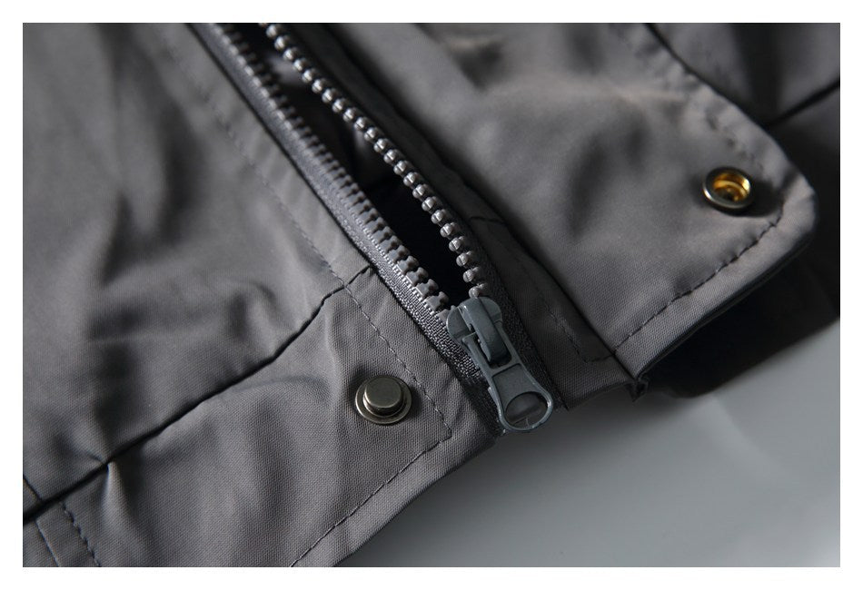 Close-up of the charcoal-gray jacket's front zipper and metal snap fasteners.