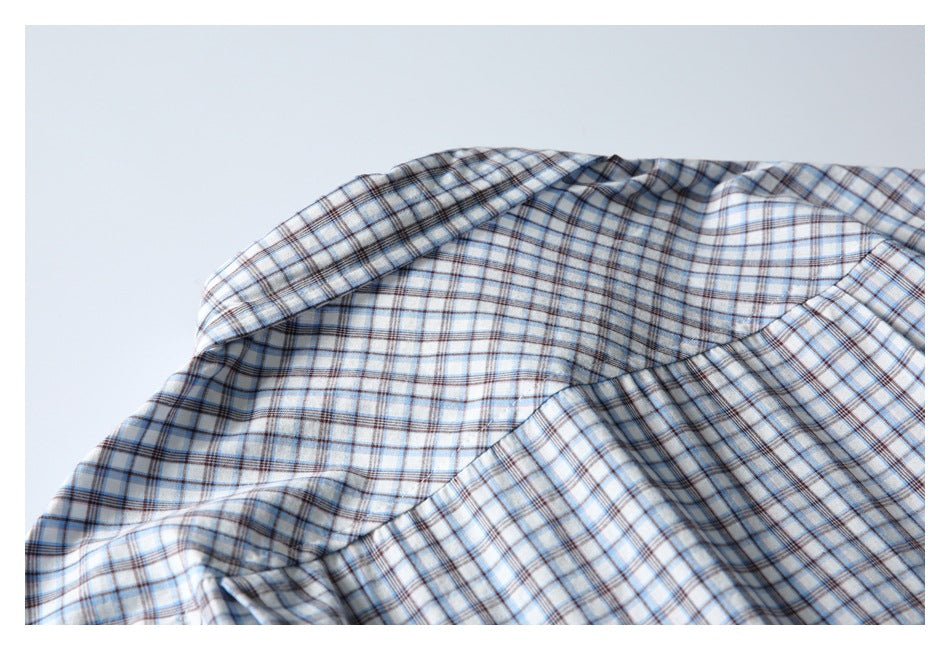 Close-up of the plaid shirt's shoulder and upper-back seams in white, blue, and brown checks.