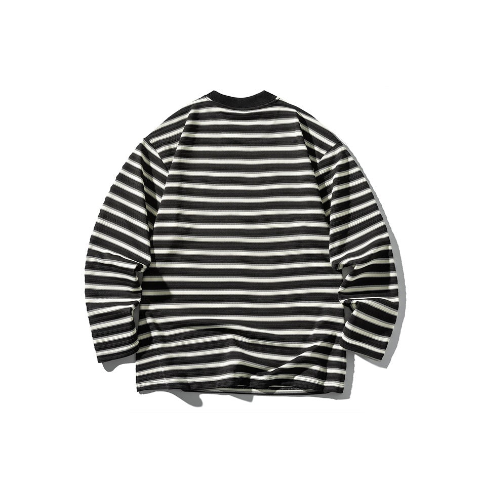 Flat lay of a long-sleeve shirt with black, gray, and white horizontal stripes and a black collar.