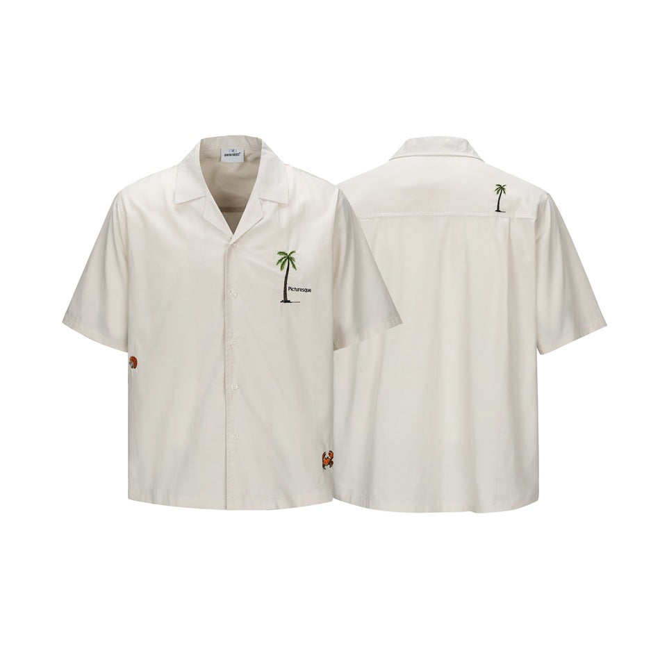 Ivory short-sleeve camp-collar shirt shown from front and back, with palm tree and small crab embroidery.