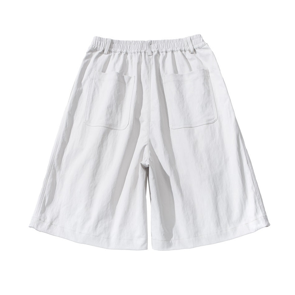 Back view of white wide-leg shorts with an elastic waistband, belt loops and two large patch pockets.