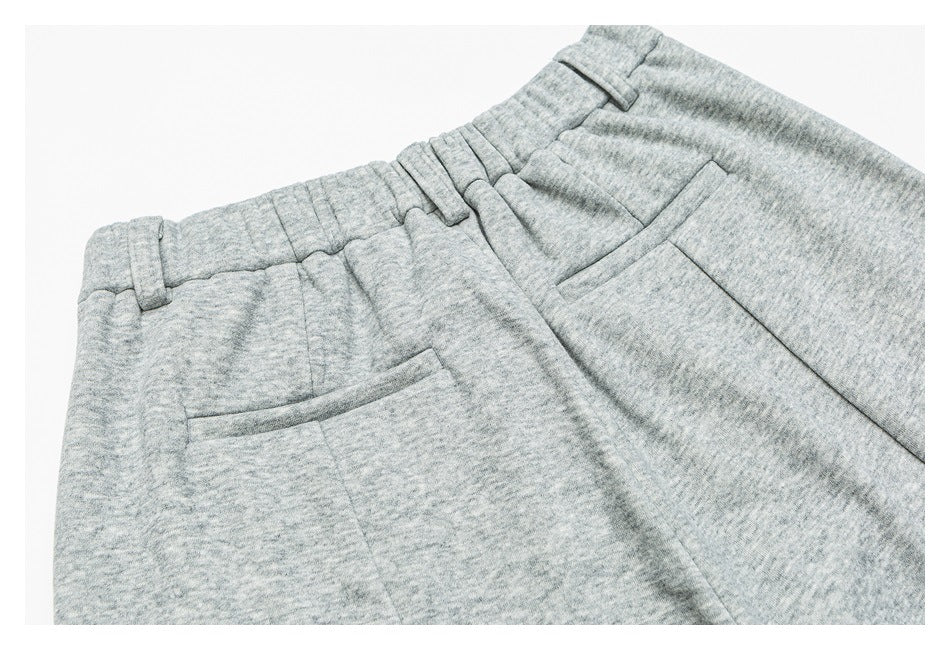 Close-up of heather gray pants showing the waistband, belt loops, fly, and front pockets.