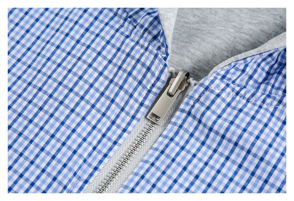 Close-up of a metal zipper between blue-and-white gingham panels, with gray hood lining above.