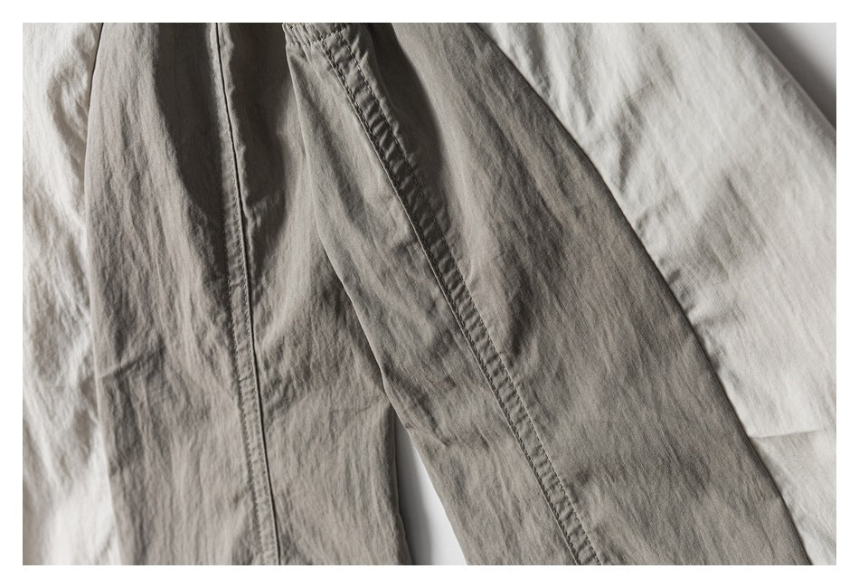 Close-up of a long stitched seam on a light neutral garment.
