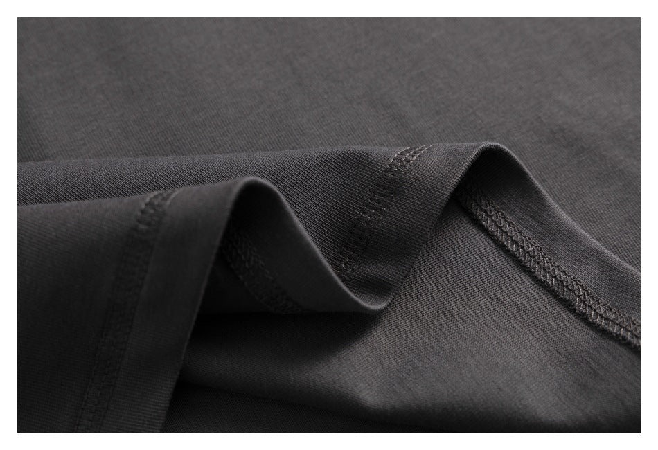 Close-up of charcoal fabric with folded, overlocked seams.