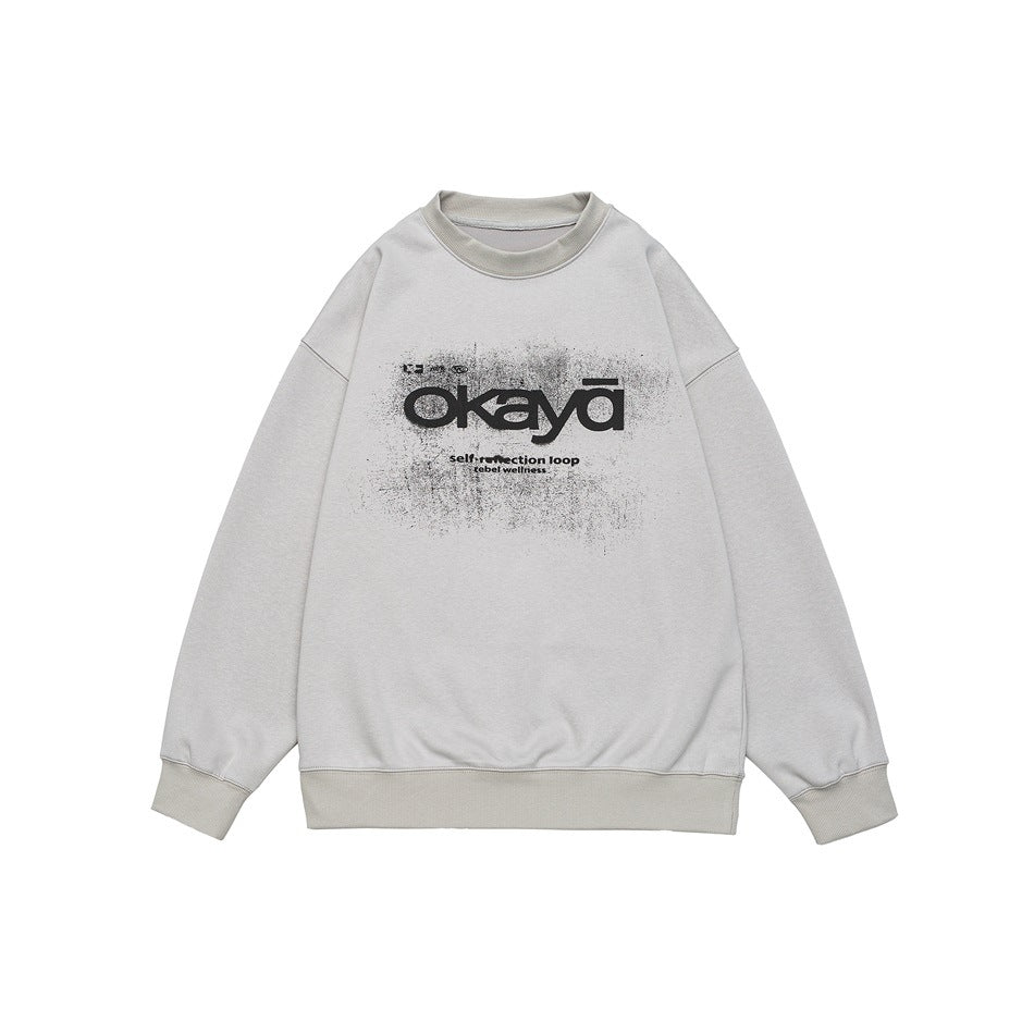 Gray crew-neck sweatshirt flat lay with black distressed okaya graphic and ribbed collar, cuffs and hem