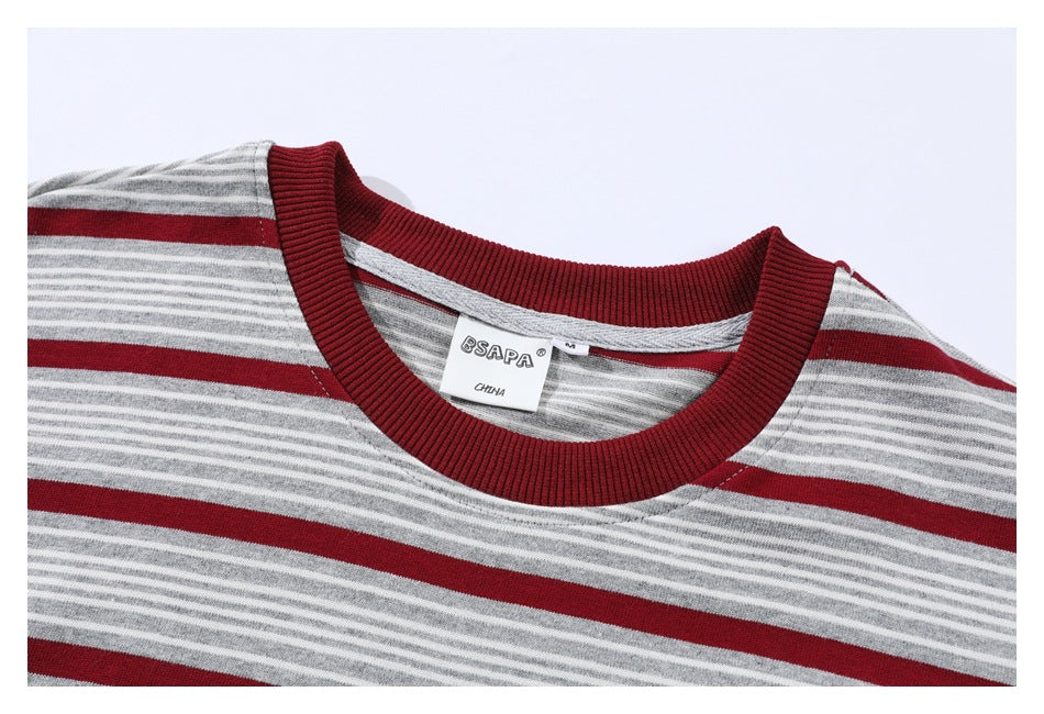 Close-up of a gray-and-white striped shirt neckline with a ribbed burgundy collar and sewn-in label.