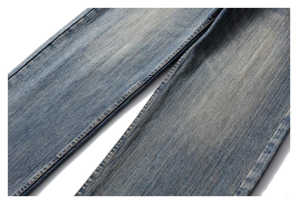 Close-up of the legs of faded blue jeans, showing the denim weave and subtle wash variations.
