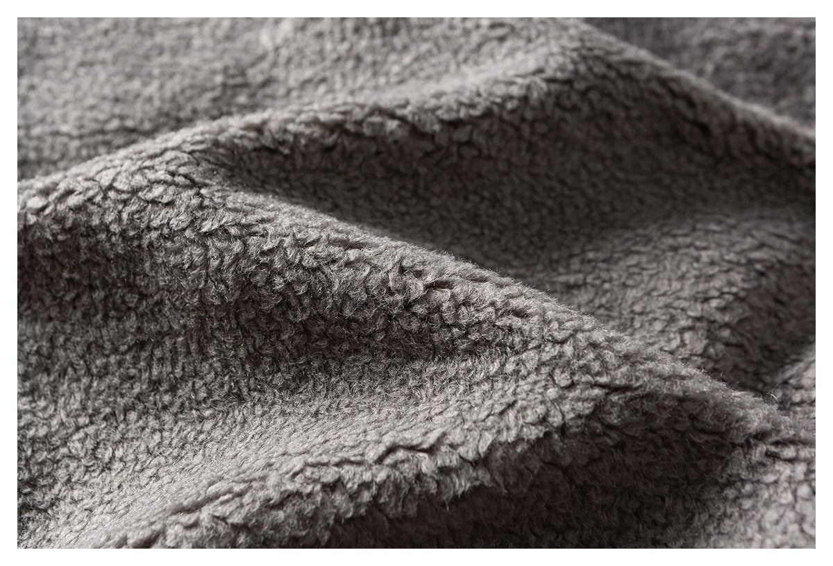 Close-up of gray fleece folded into soft ridges, showing its textured surface and edge stitching.