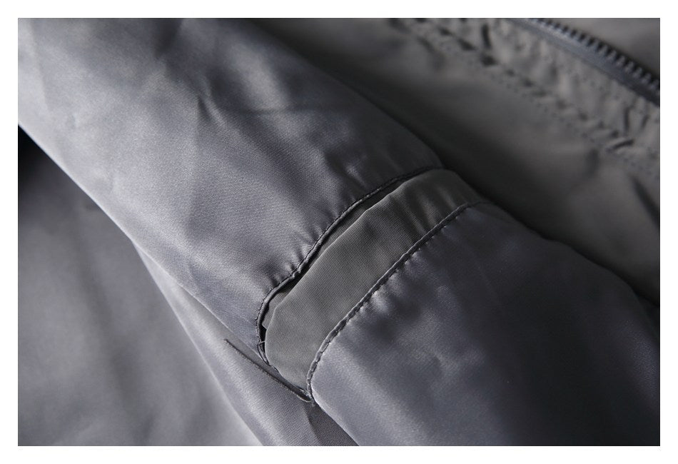 Close-up of a stitched cuff tab on the charcoal-gray jacket sleeve.