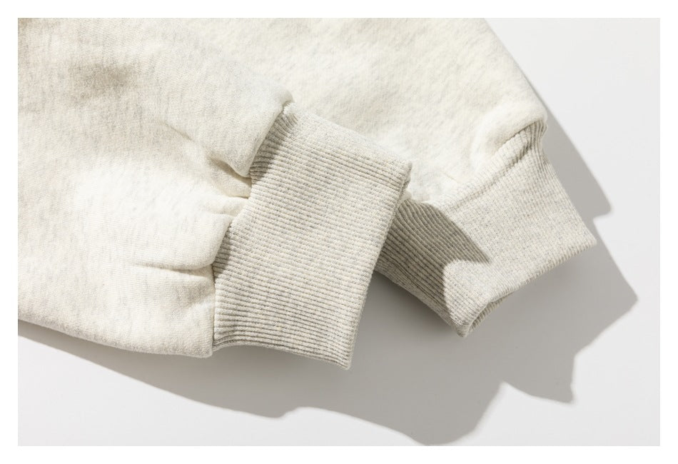 Close-up of a cream garment sleeve with a wide, ribbed light gray cuff.