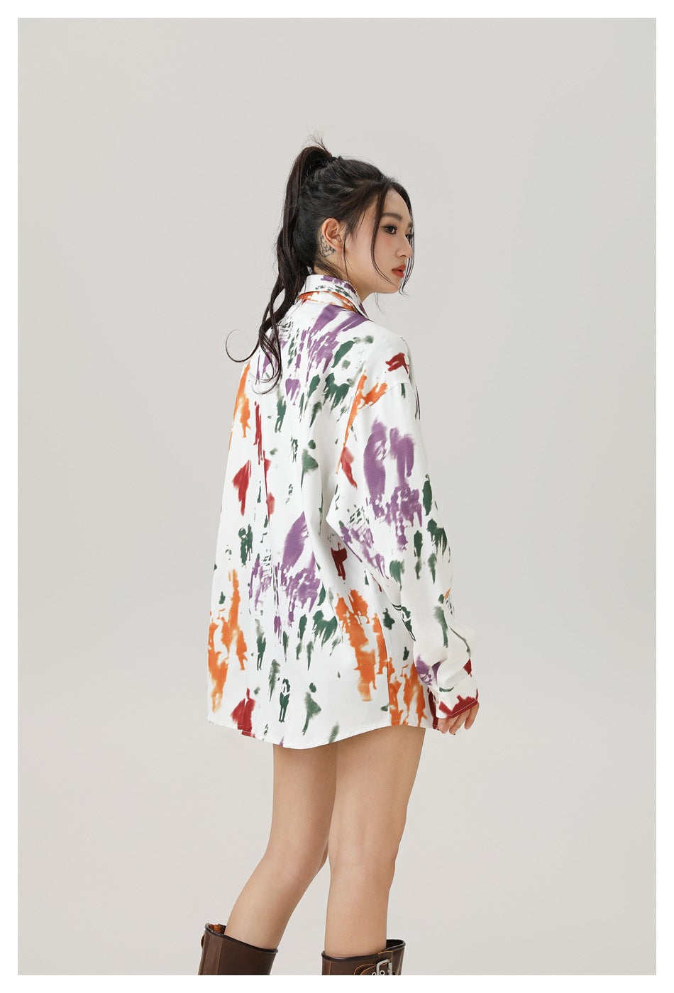 Model wearing an oversized white shirt with colorful abstract prints, shown from the back and side.