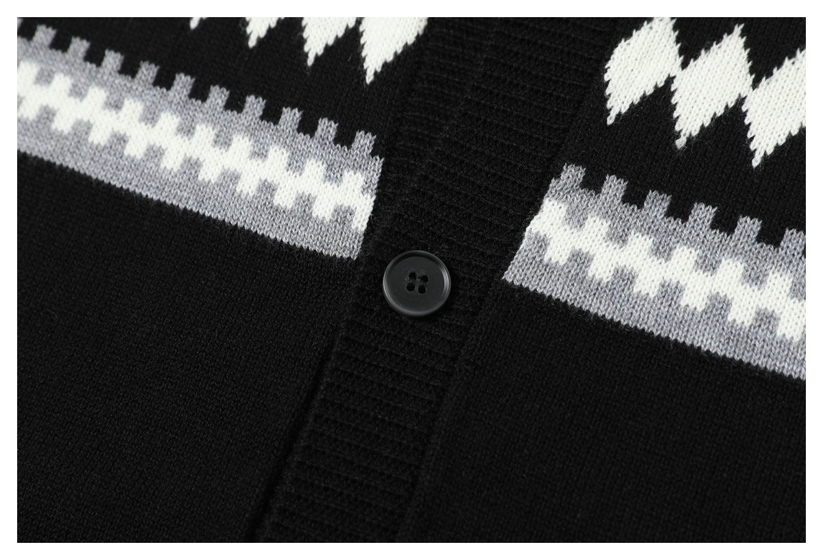 Close-up of a black knit cardigan button placket with a black button and white and gray geometric bands.