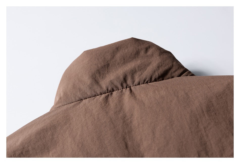 Close-up of the brown jacket's raised collar against a light background.